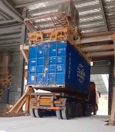 Container tilter loading cargo in factory